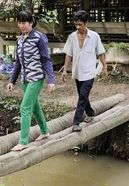 Duong Thanh Phong und seine Frau laufen über Baumstämme die als Brücke dienen 